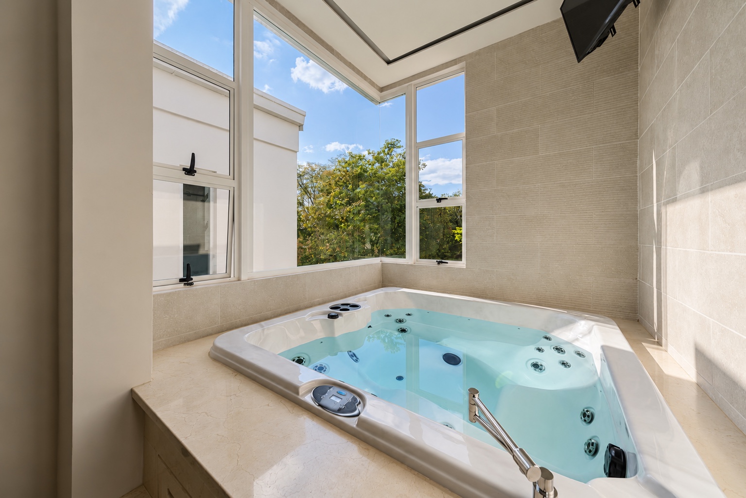 Jacuzzi junto a ventanales con vista a los árboles