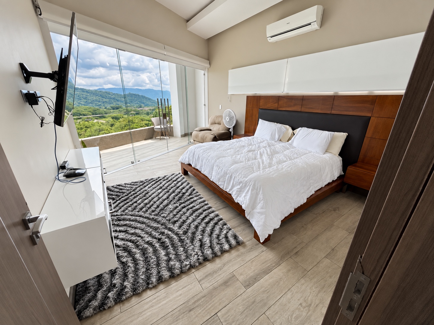 Habitación principal con cama blanca y vista a las montañas