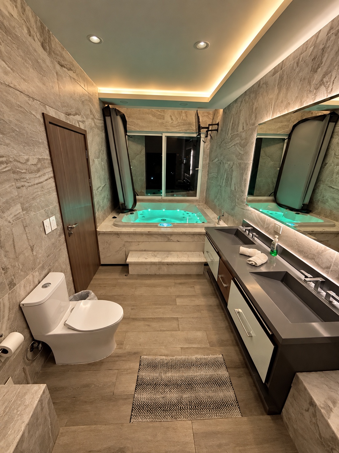 Baño con lavabos dobles y jacuzzi iluminado