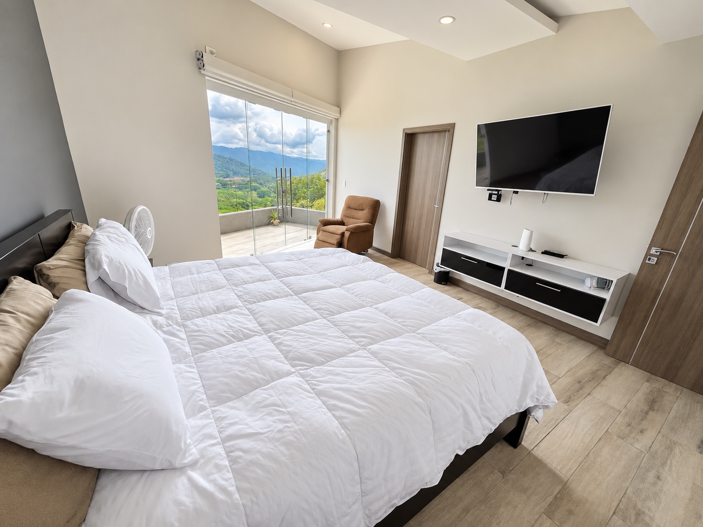 Vista de la cama king, televisión y balcón de Master bedroom 2